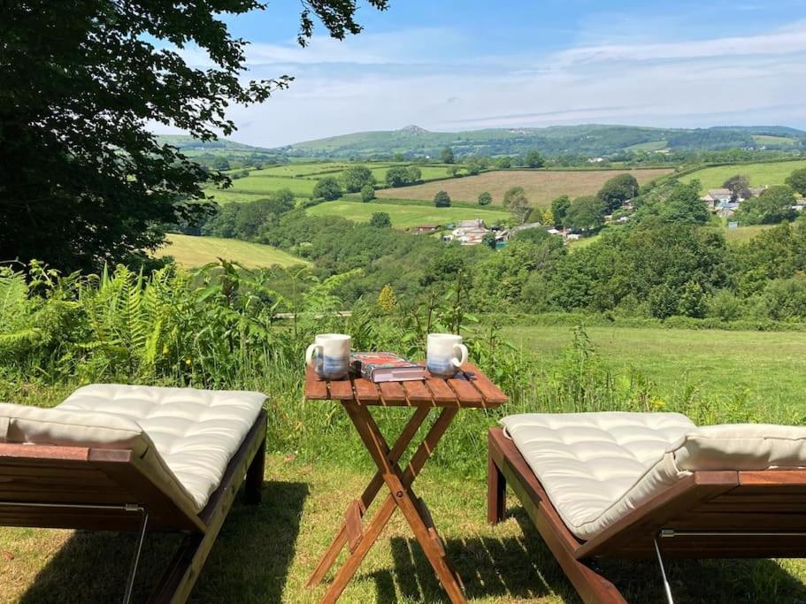 a picnic table with two chairs and a view of a field at Cargibbitt Annexe in Liskeard