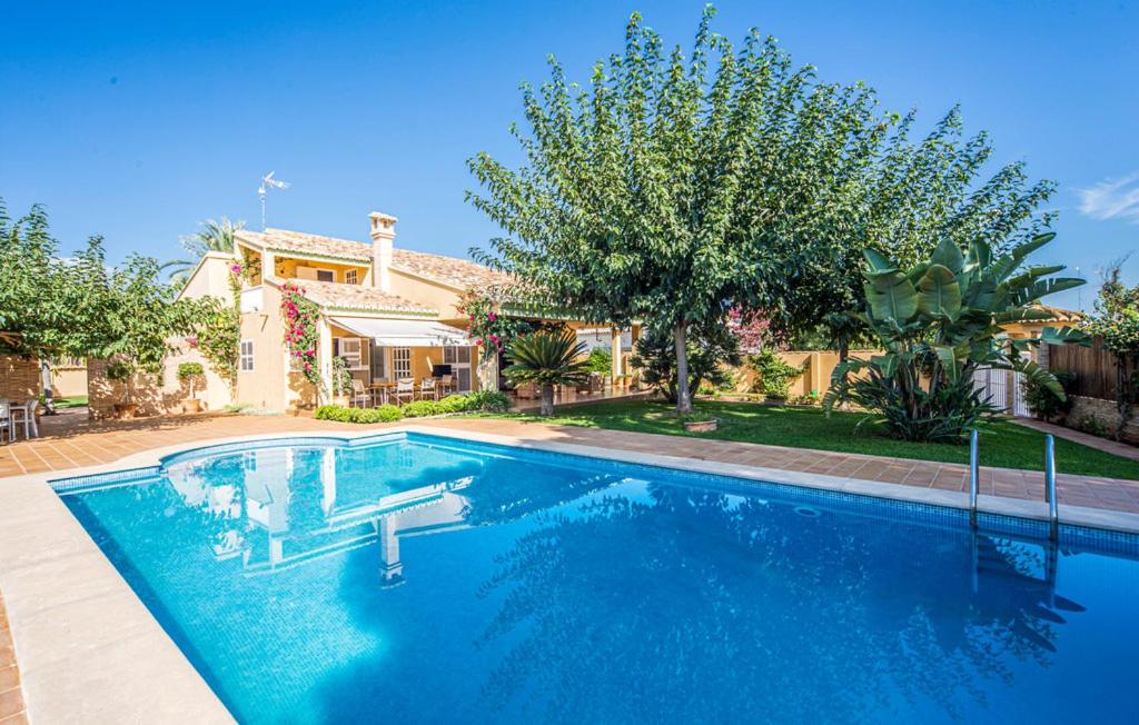 a swimming pool in front of a house at Agradable Villa junto al mar con piscina in Valencia