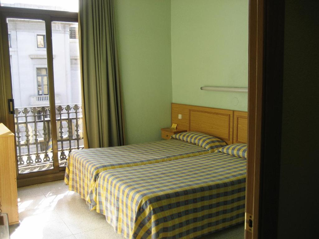 Postel nebo postele na pokoji v ubytování Hostal Nuevo Colon