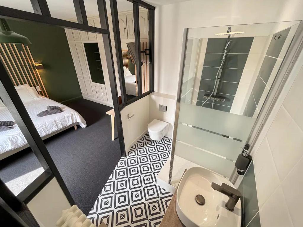 La petite salle de bains est pourvue de toilettes et d'un lavabo. dans l'établissement La Longère de Neuville-Futuroscope-Poitiers, à Neuville-du-Poitou