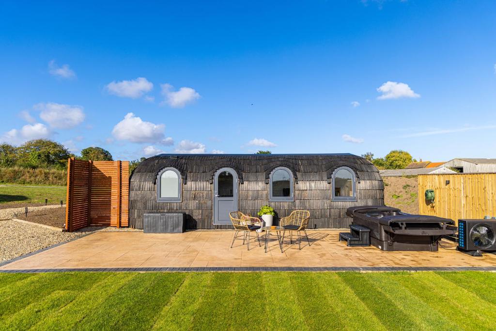 a backyard with a stone building with a grill at Veiko - Mayflower Meadow in Brandesburton