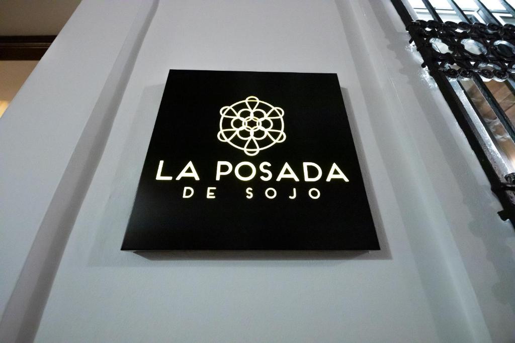 een bord voor la posada de sono op een tafel bij La Posada De Sojo in Córdoba