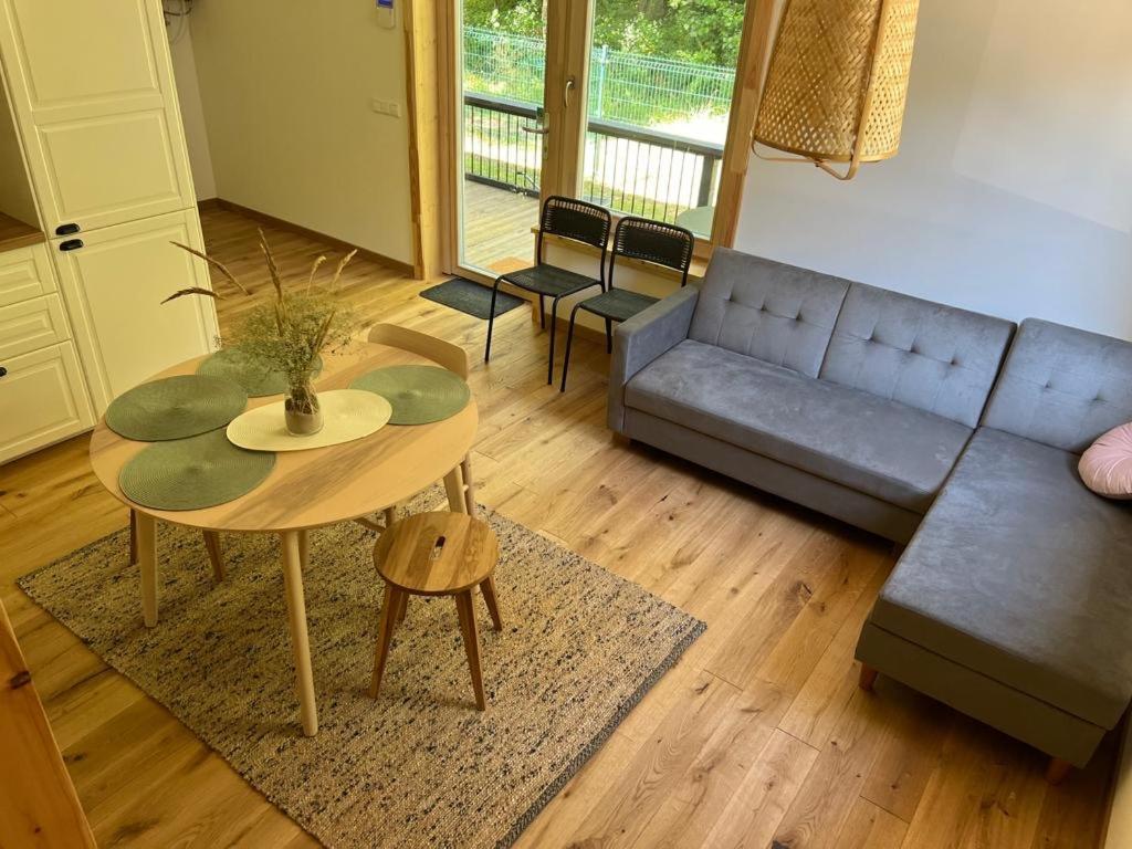 a living room with a table and a couch at Rugio namai-Rye house in Palanga