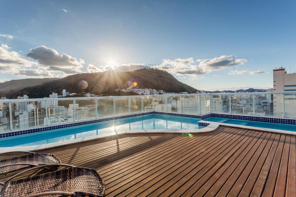 einen Balkon mit einem Pool auf einem Gebäude in der Unterkunft Victory Suites in Juiz de Fora