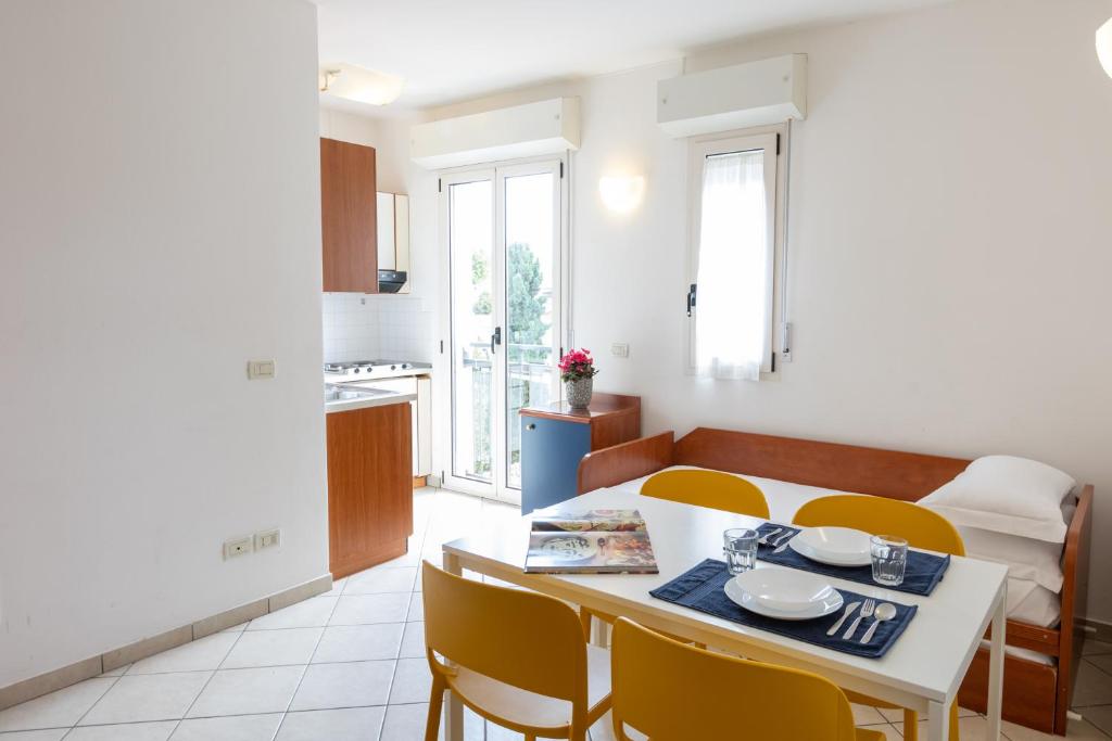 una cucina e una sala da pranzo con tavolo e sedie di Residence Mimosa a Rimini