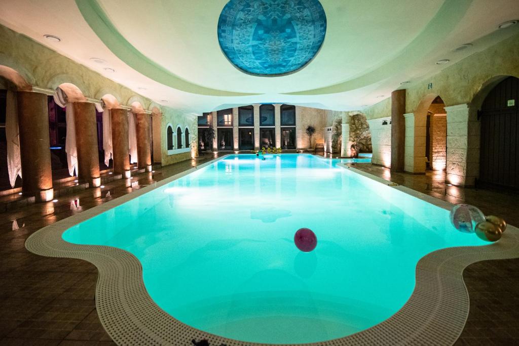 a large swimming pool in a building with a ceiling at Hotel Azzun Orient SPA&Wellness in Kromerowo