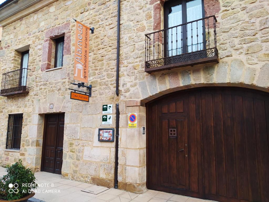 un edificio de piedra con dos puertas de garaje. en Apartamentos Alameda en Sigüenza