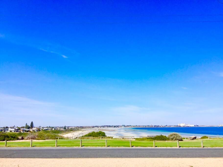a view of a beach and the ocean from a road at SALT @ North Beach WALLAROO (absolute beachfront) in Wallaroo