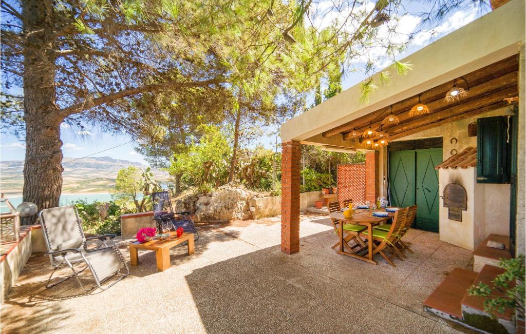 Cette maison dispose d'une terrasse avec une table et des chaises. dans l'établissement Stunning Home In Sambuca Di Sicilia With House Sea View, à Sambuca di Sicilia