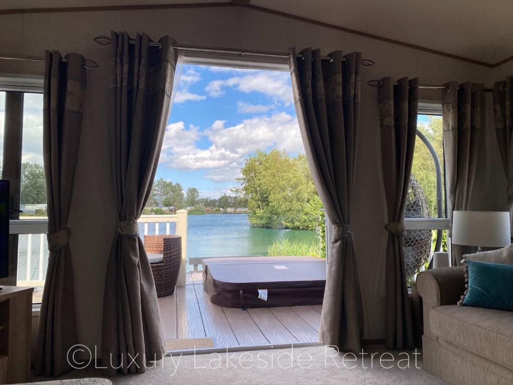um quarto com uma janela com vista para a água em Lakeside Retreat With Hot Tub & Fishing Peg at Tattershall Lakes Country Park em Tattershall
