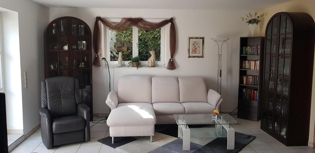 a living room with a couch and a chair and a window at ruhige Ferienwohnung in Waldnähe in Rheinbach
