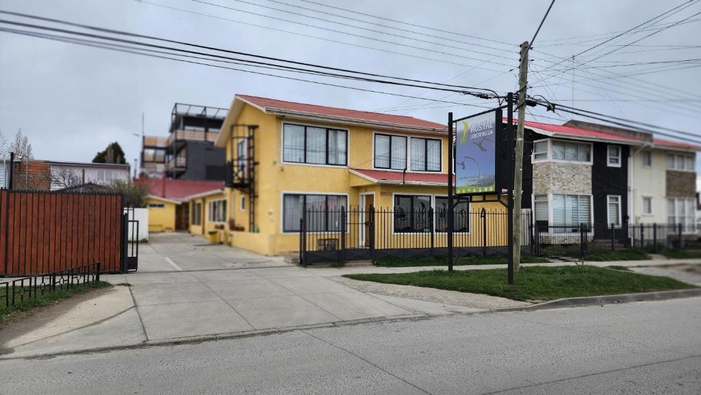 żółty dom po stronie ulicy w obiekcie Hostal Loreto Belen w mieście Puerto Natales
