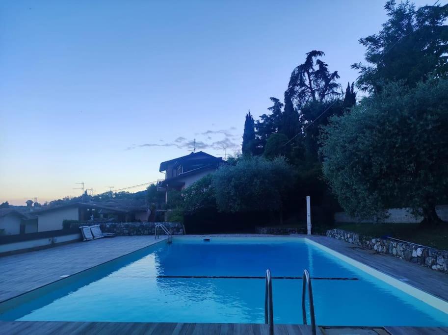 a swimming pool with blue water in a yard at Casa in residence - Padenghe sul Garda in Padenghe sul Garda
