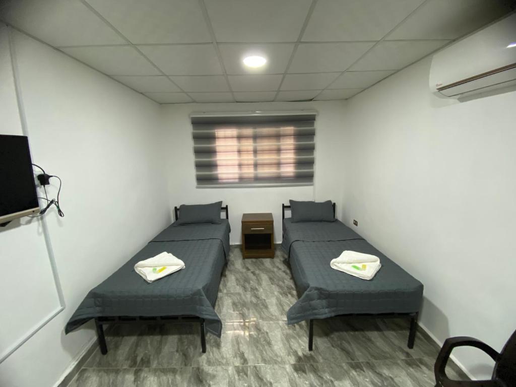 ein Krankenhauszimmer mit 2 Betten und einem TV in der Unterkunft Omar Apartment in Wadi Musa
