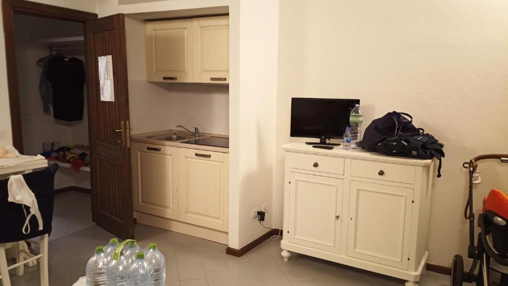 a kitchen with white cabinets and a television on a counter at Casa Esteve in Terrassa