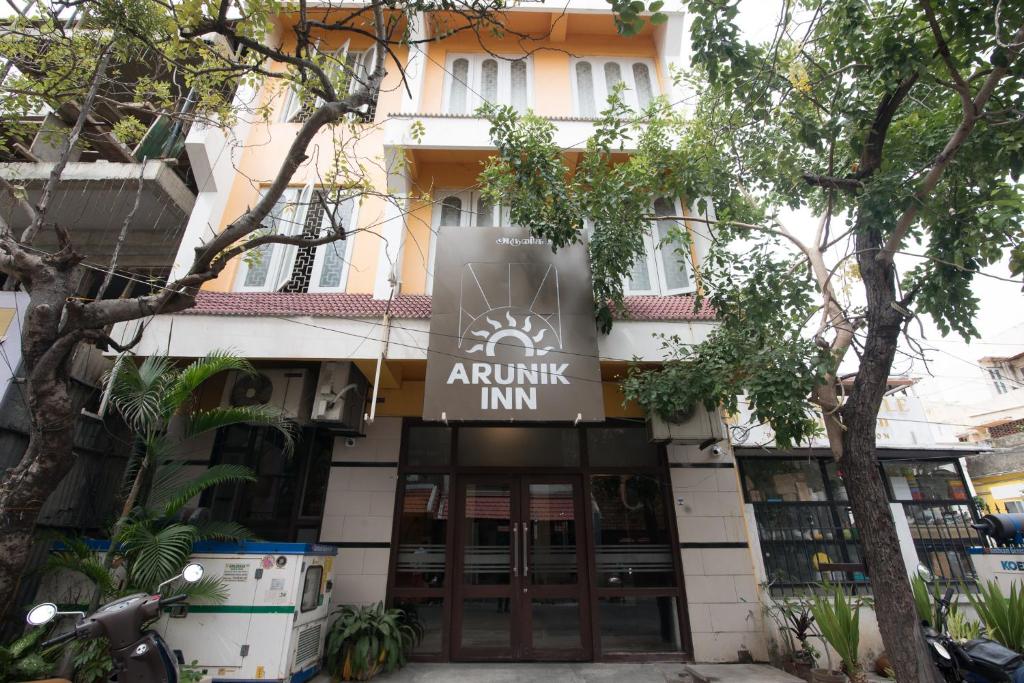 a building with a sign that reads arusha inn at Arunik Inn in Puducherry