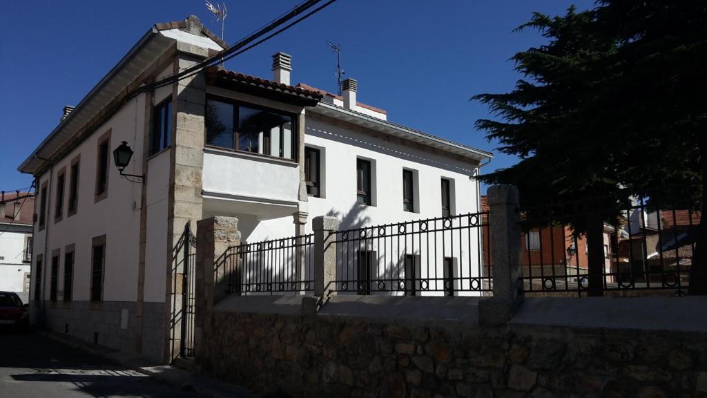 ein weißes Haus mit einem Zaun davor in der Unterkunft Casa del Cura in Las Navas del Marqués