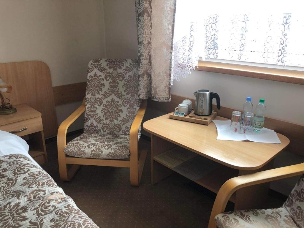 um quarto de hotel com uma secretária, uma cadeira e uma cama em MOTEL ZADOIL *** em Maków Podhalański
