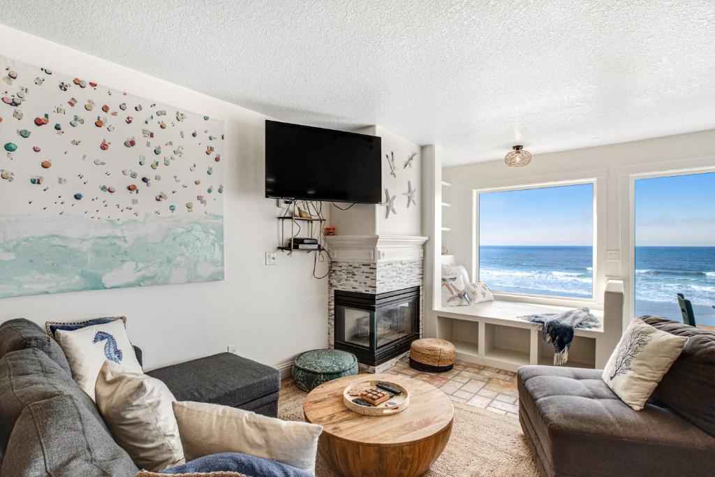 a living room with a fireplace and the ocean at Sand Castle Villa in Rockaway Beach