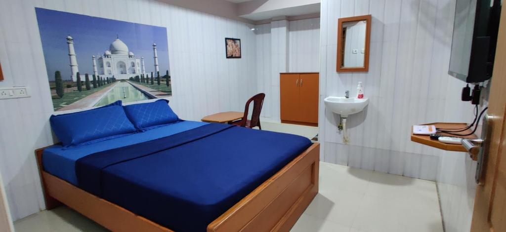 a bedroom with a blue bed and a view of a building at S.S.K RESIDENCY in Chennai