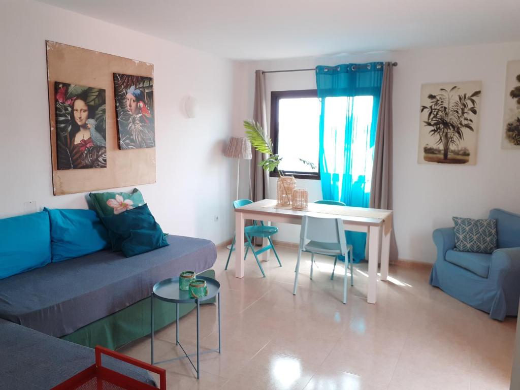 a living room with a blue couch and a table at Oasis Waves House in Corralejo