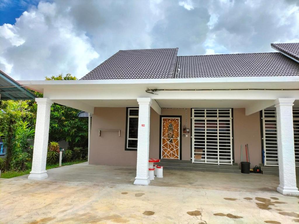ein kleines Haus mit einer Terrasse davor in der Unterkunft Wipah Guest House in Kampung Lundang, Kota Bharu in Kota Bharu