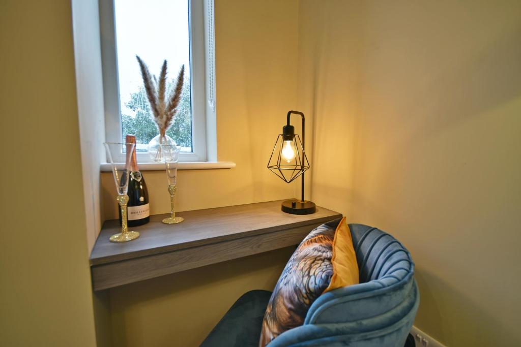 a room with a window and a chair with a pillow at Moat House in Rawtenstall