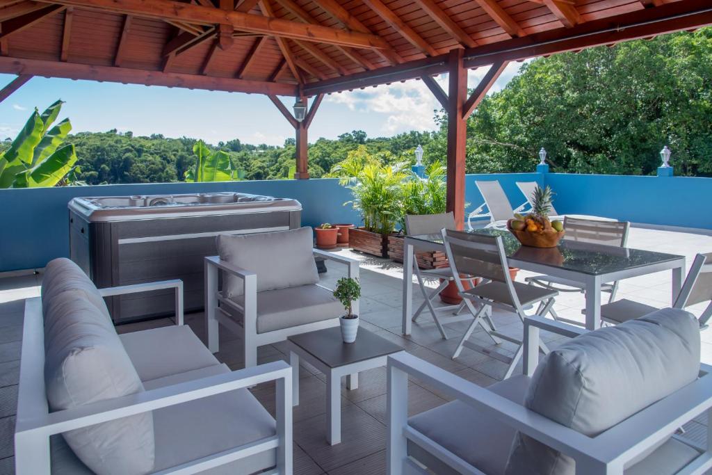 a patio with a table and chairs and a grill at Les Hauts de Sainte-Anne "2 Spas privatifs" in Sainte-Anne