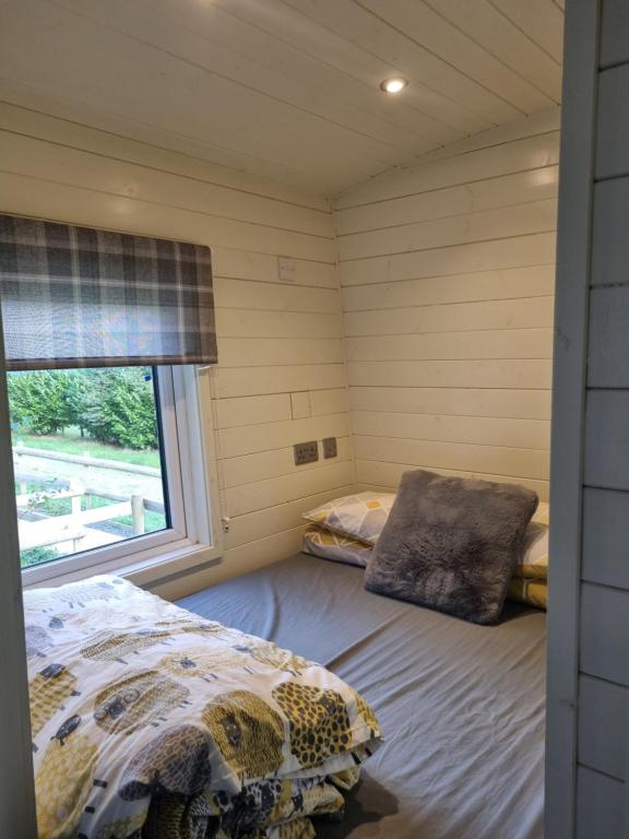 GarthbeibioにあるGlamping Hut - Riverview 5のベッドと窓が備わる小さな客室です。
