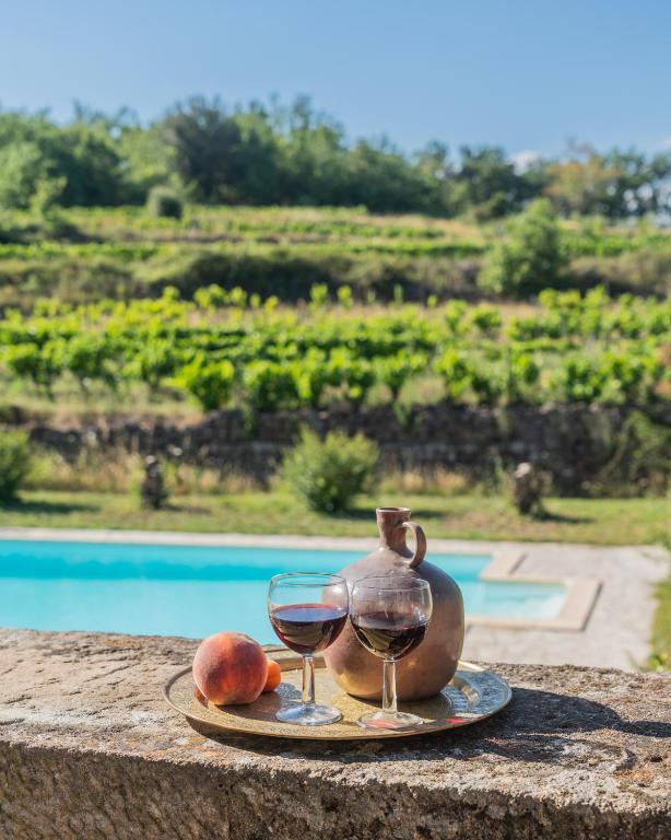 une assiette avec un verre de vin et un pichet de verres à vin dans l'établissement Le Domaine Morleau, à Lablachère