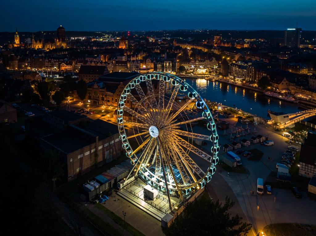 a ferris wheel in a city at night at Baltic Gdansk OLD TOWN in Gdańsk
