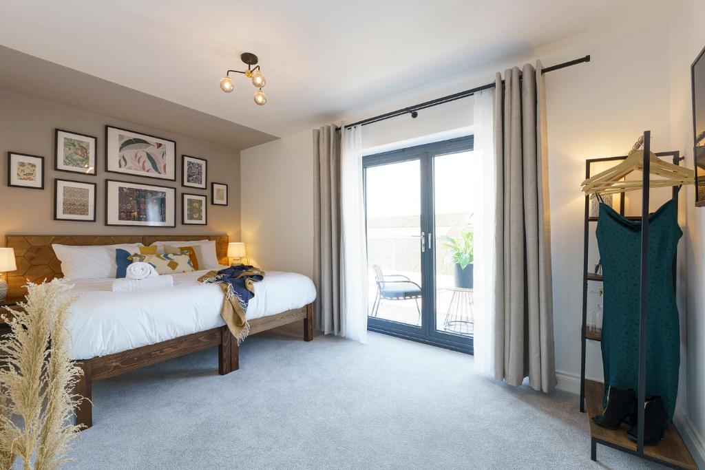 um quarto com uma cama e uma porta de vidro deslizante em Honeysuckle - 1 Bedroom Luxury Apartment by Mint Stays em Bristol