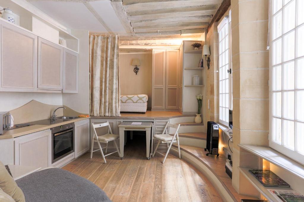 a kitchen with a table and chairs in a room at Louvre Charmant Studio in Paris