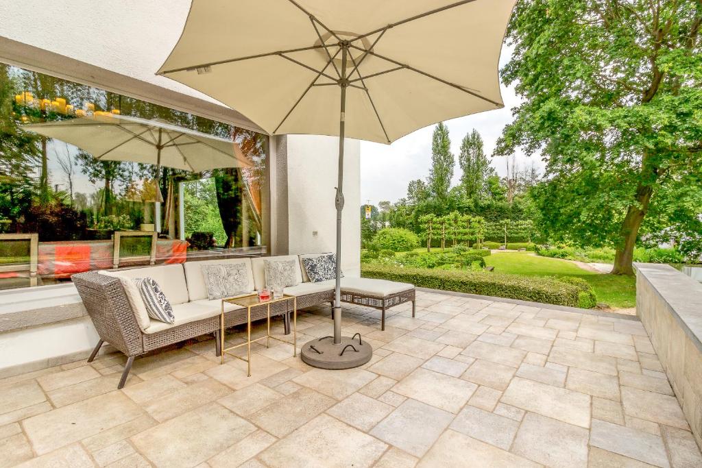 a patio with a couch and an umbrella at Raesborre in Leuven