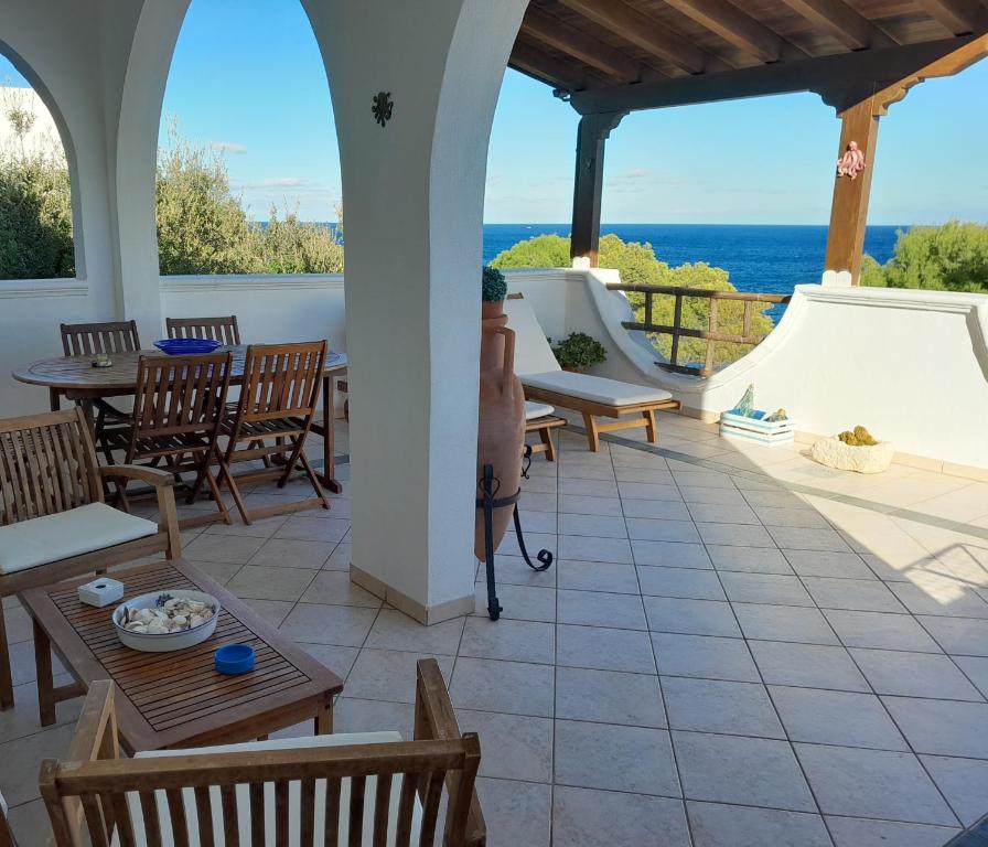eine Terrasse mit Tischen und Stühlen und Meerblick in der Unterkunft Marina in Marittima
