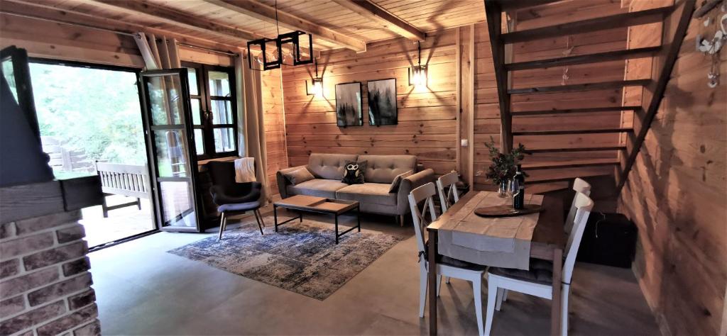 - un salon avec un canapé et une table dans l'établissement Ostoja Krasne, à Uścimów