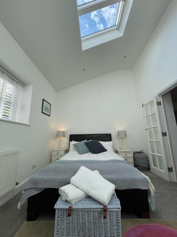 a bedroom with a large bed with two windows at Selwood Cottage Annex in Frome