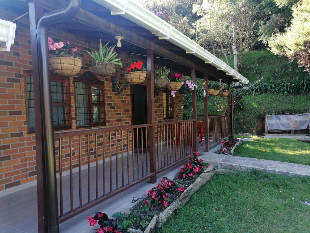 um alpendre com flores em cestos e uma cerca em Finca la Mariposa, Santa Elena em Santa Elena