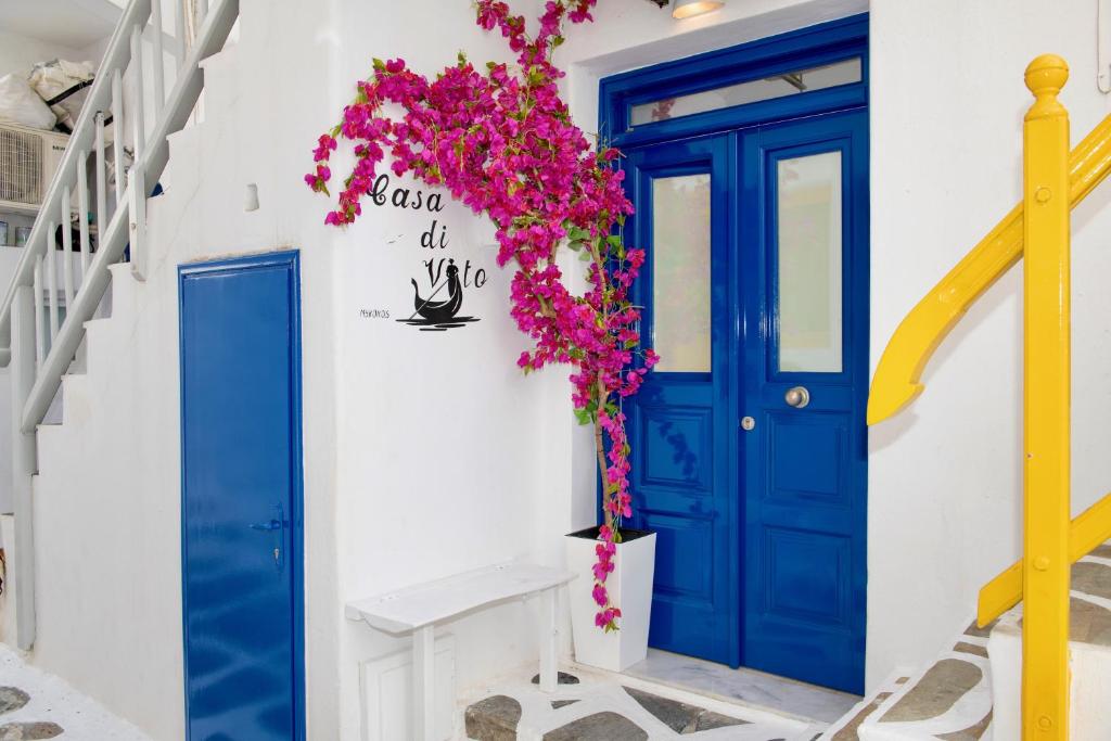 una porta blu su un edificio bianco con fiori di Casa di Vito a Mykonos Città