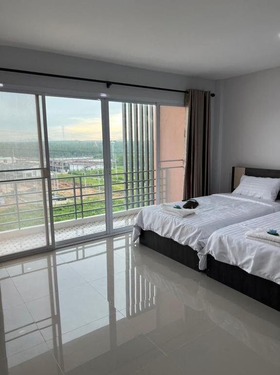 a bedroom with a bed and a large window at Thana Apartment in Ban Phan Sadet Nai