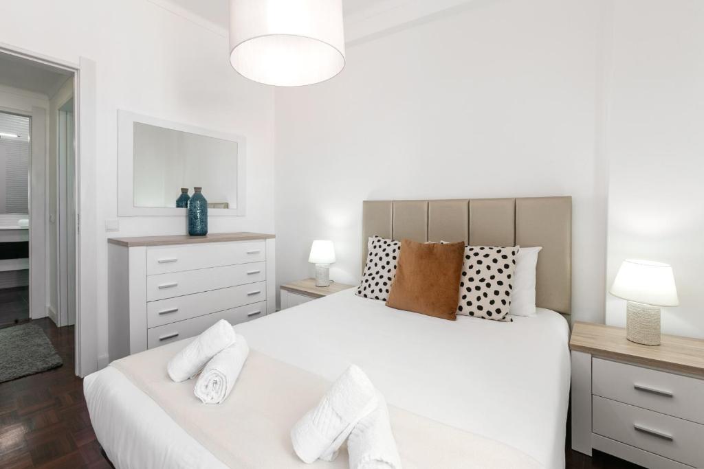 - une chambre avec un grand lit blanc et une commode dans l'établissement Casa da Marginal, à Peniche