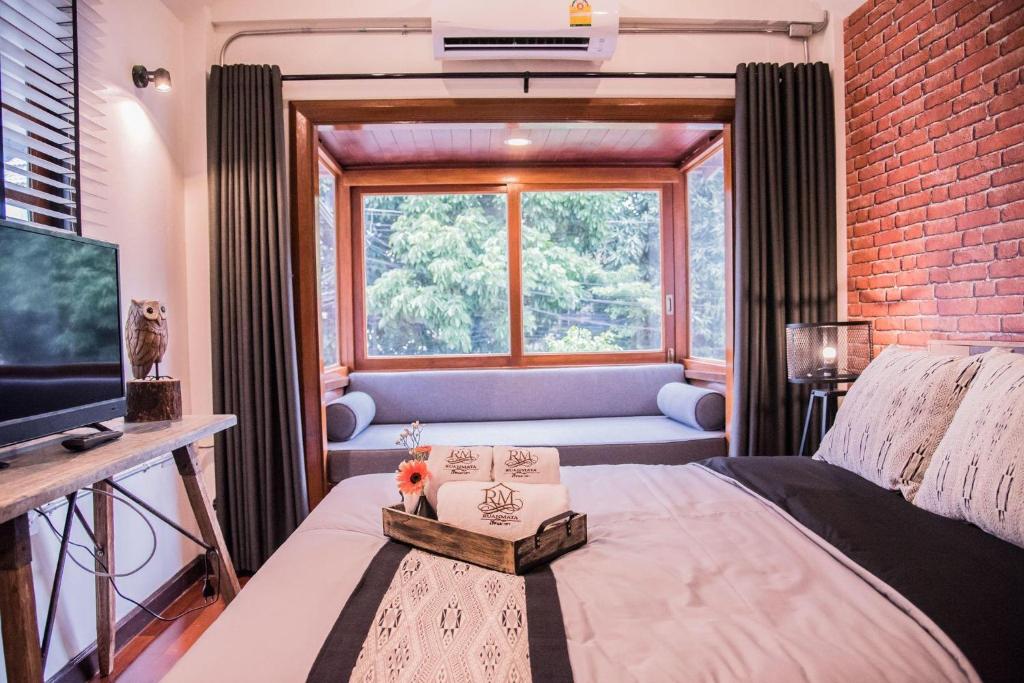 a bedroom with a bed and a large window at Ruanmata Homestay in Chiang Mai