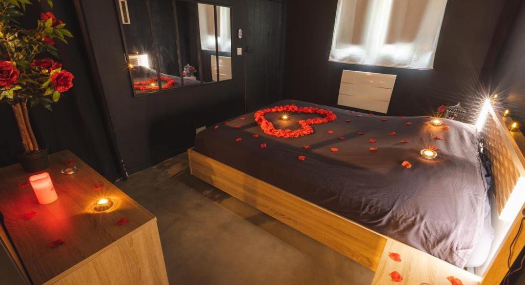 a bedroom with a bed with red roses on it at Eden House, Cocon intimiste et romantique avec jacuzzi in Carpentras