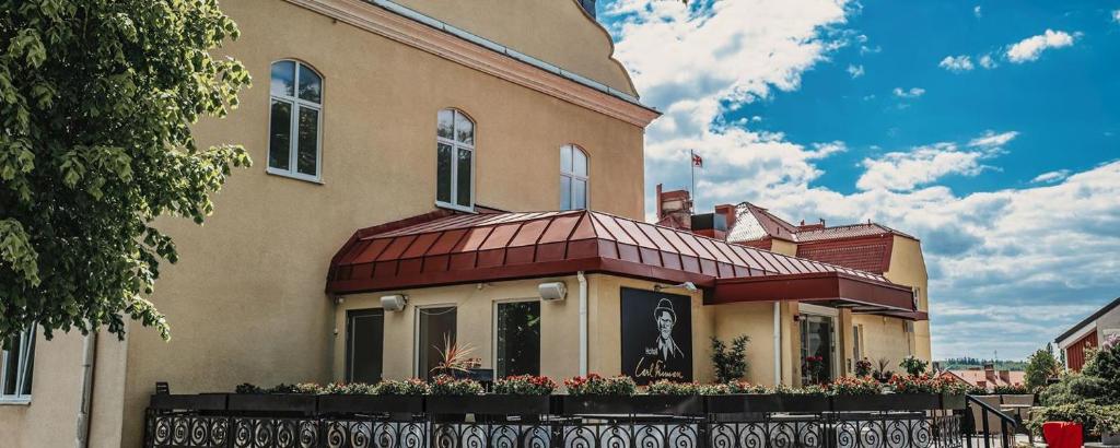 une maison avec une clôture devant elle dans l'établissement Hotell Carl Friman, à Motala