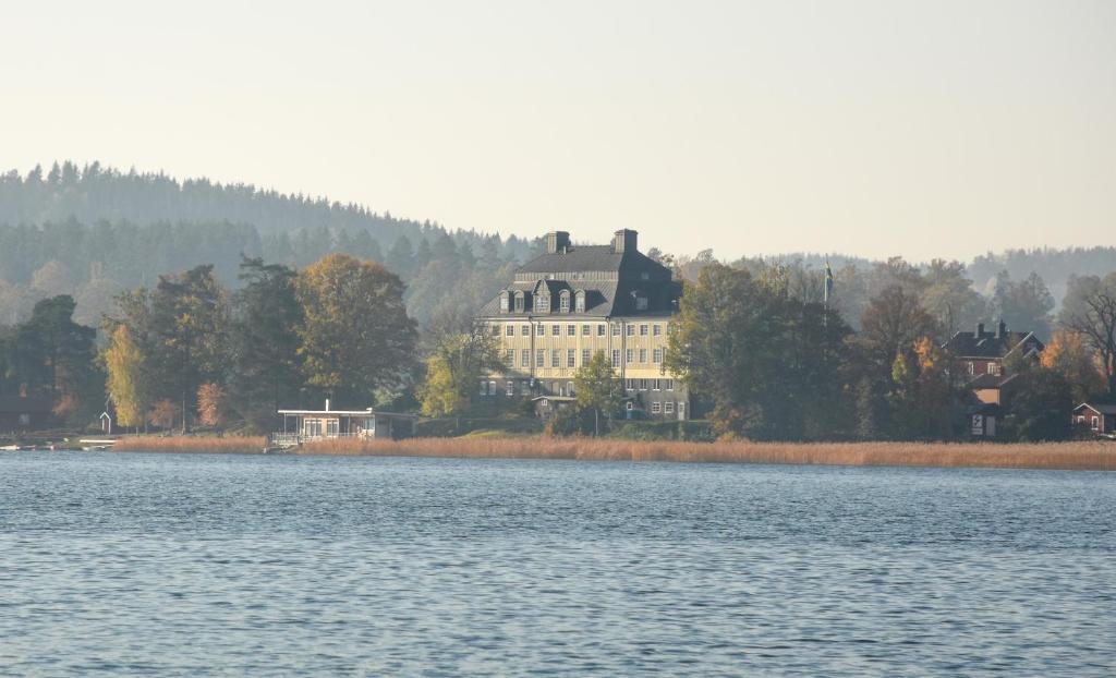 uma grande casa sentada ao lado de um lago em Rimforsa Strand em Rimforsa