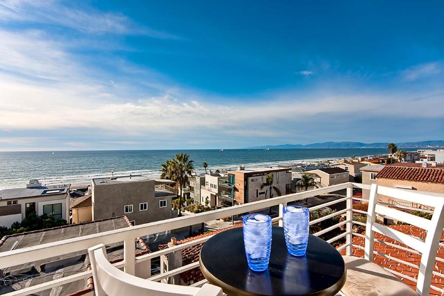 2 vasos en una mesa en un balcón con vistas al océano en Beautiful Views - Sand Section of Manhattan Beach 2 Bed/2 Bath en Manhattan Beach