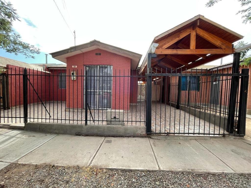 a black fence in front of a red building at Casa la serena condominio D. Gabriela in La Serena