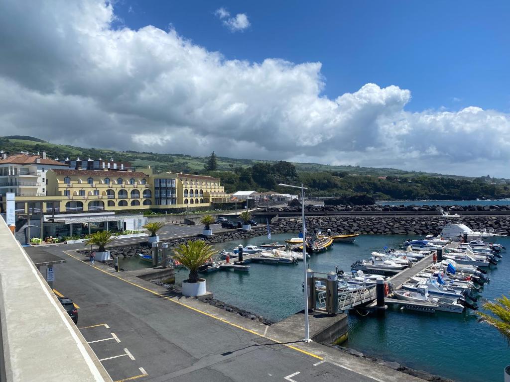 a marina with boats in the water and buildings at Vinha da Areia Beach Hotel in Vila Franca do Campo