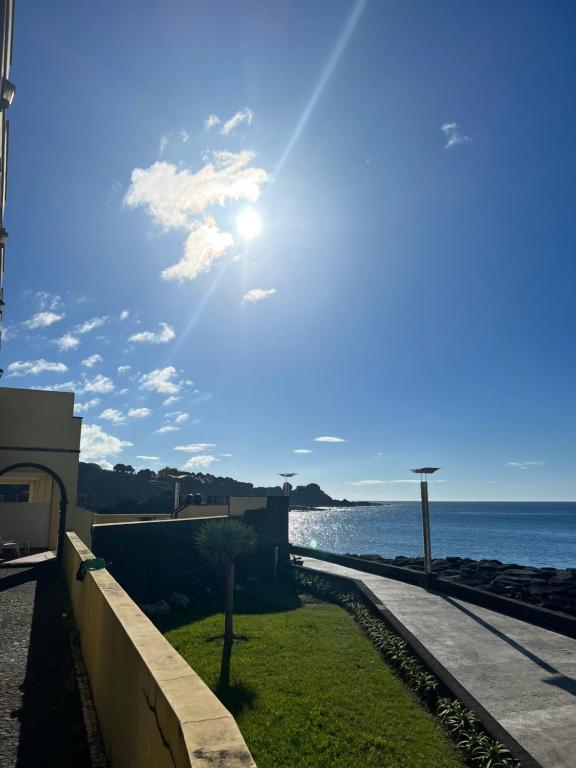 a view of the ocean with the sun in the sky at Vinha da Areia Beach Hotel in Vila Franca do Campo