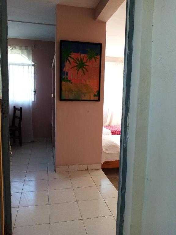 un pasillo que conduce a un dormitorio con una pintura en la pared en Apartamento en planta alta, a pie de calle, en Cozumel